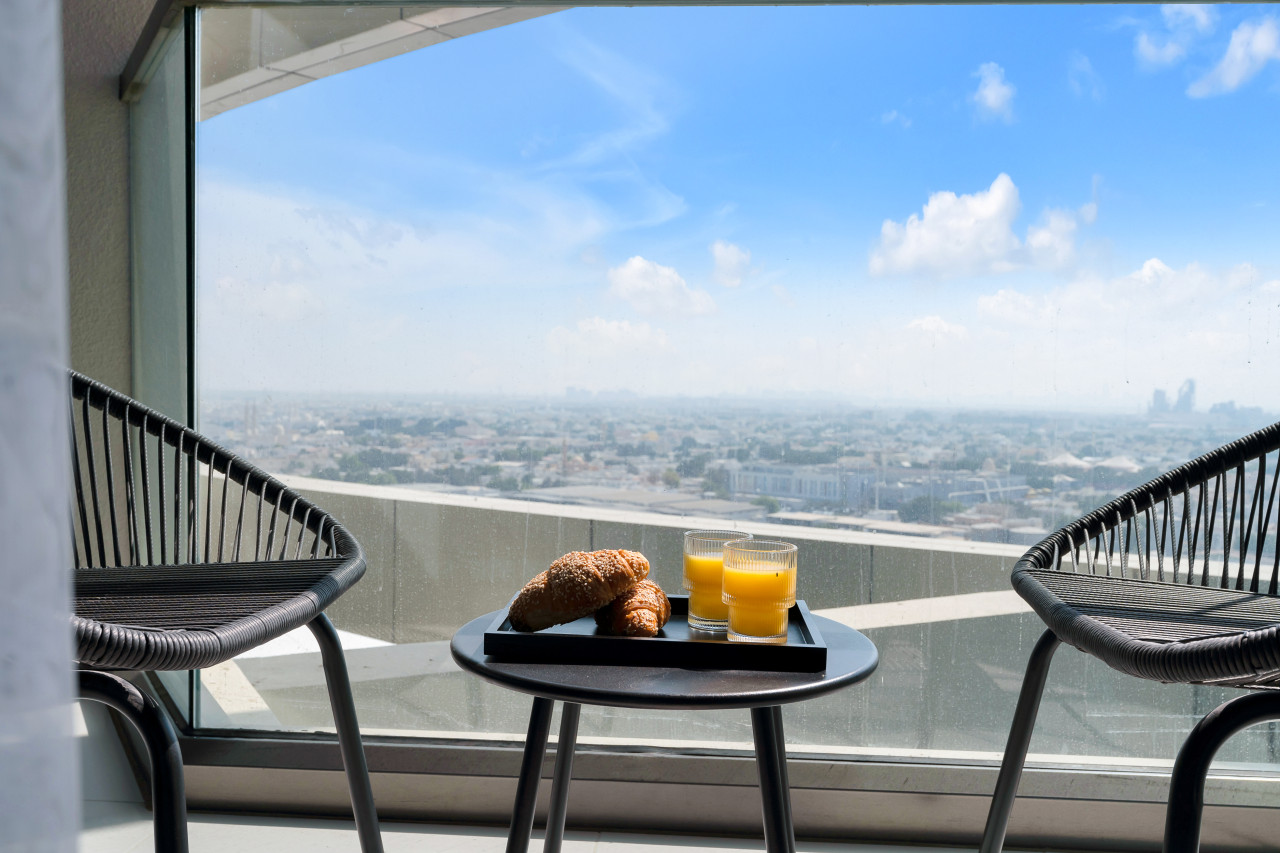 Balcony breakfast for two looking out over Dubai from a high-floor apartment in Aykon City.