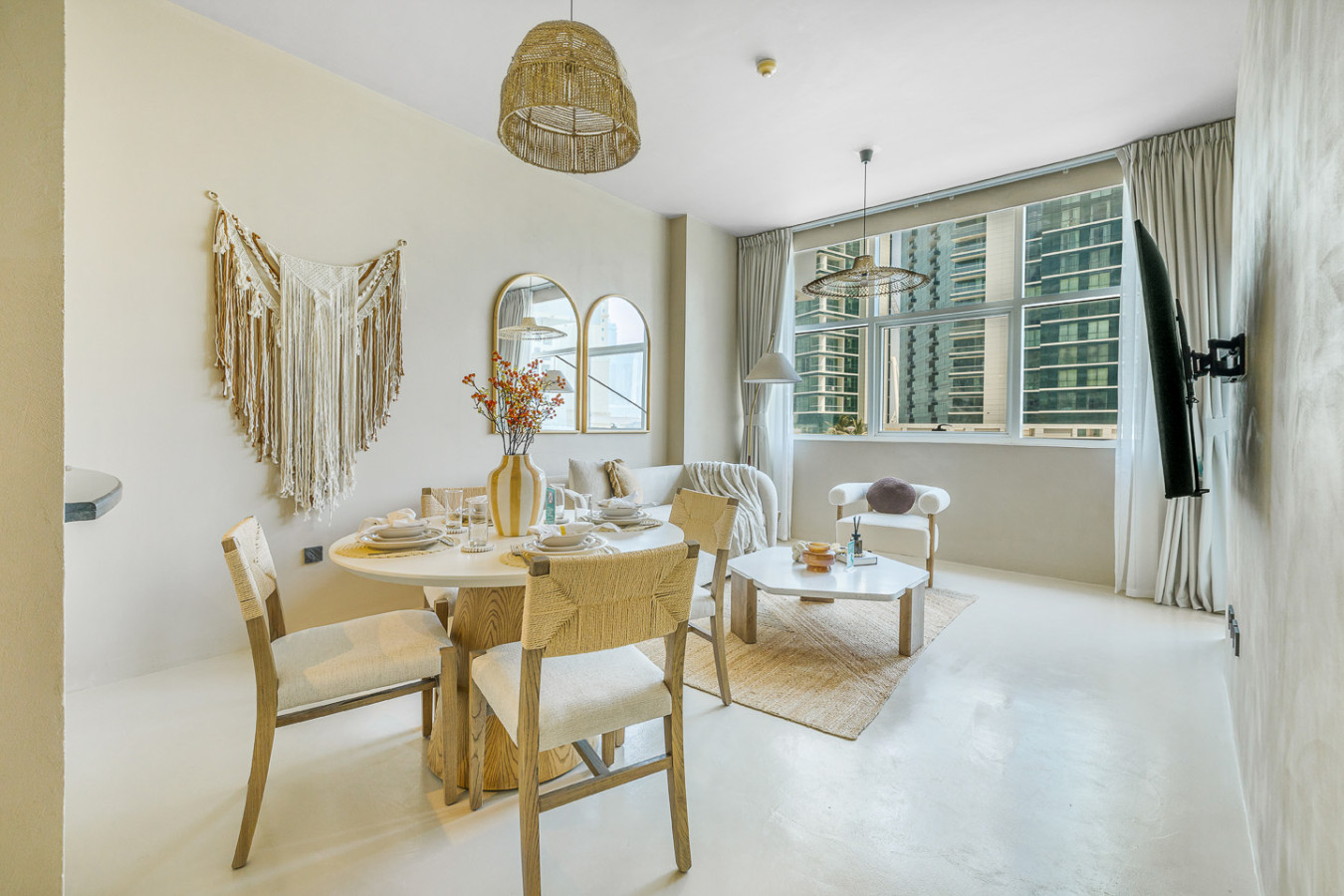 Open-plan sitting room and dining area visually divided using soft furnishings to define the layout.