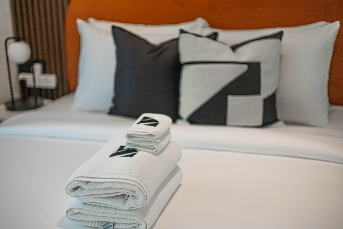 Freshly folded towels neatly placed on a bed in an Airbnb rental.