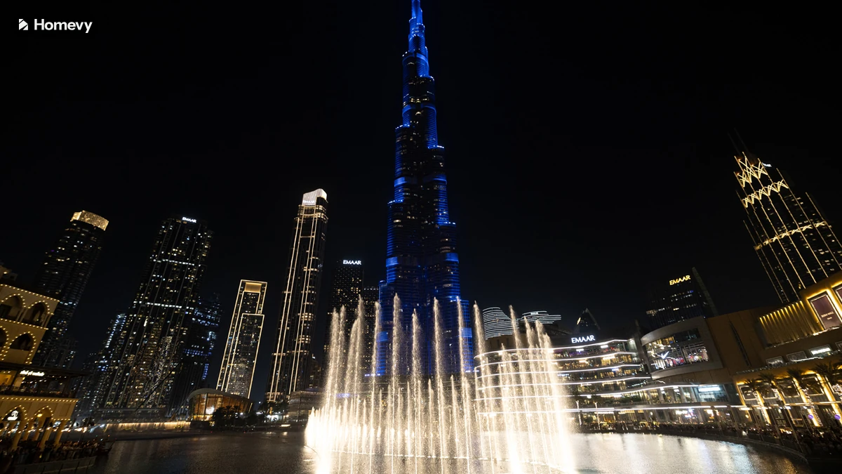 The Dubai Fountain at night below Burj Khalifa, close to Homevy's Downtown Dubai stays.