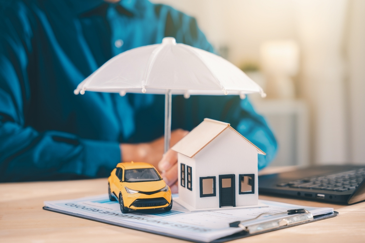 Holiday home insurance concept showing an umbrella covering a property